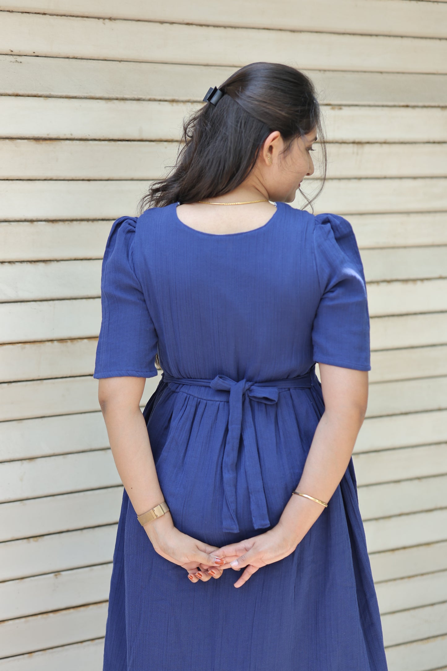 Back view of neemai navy blue feeding maxi dress with adjustable waist tie, elegant puff sleeves and bump friendly lightweight cotton fabric for summer season.