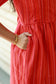 Functional side pocket detail on neemai's red striped cotton dress with breathable lightweight fabric and comfortable loose fit.