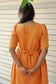 Back view of orange muslin maternity and feeding gown with adjustable waist tie, relaxed comfortable fit for pregnancy moms, plus size maternity clothing 