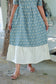 Orange muslin cotton maternity maxi dress with elegant contrast hem border, flowy silhouette, soft breathable fabric and comfortable summer wear styling.
