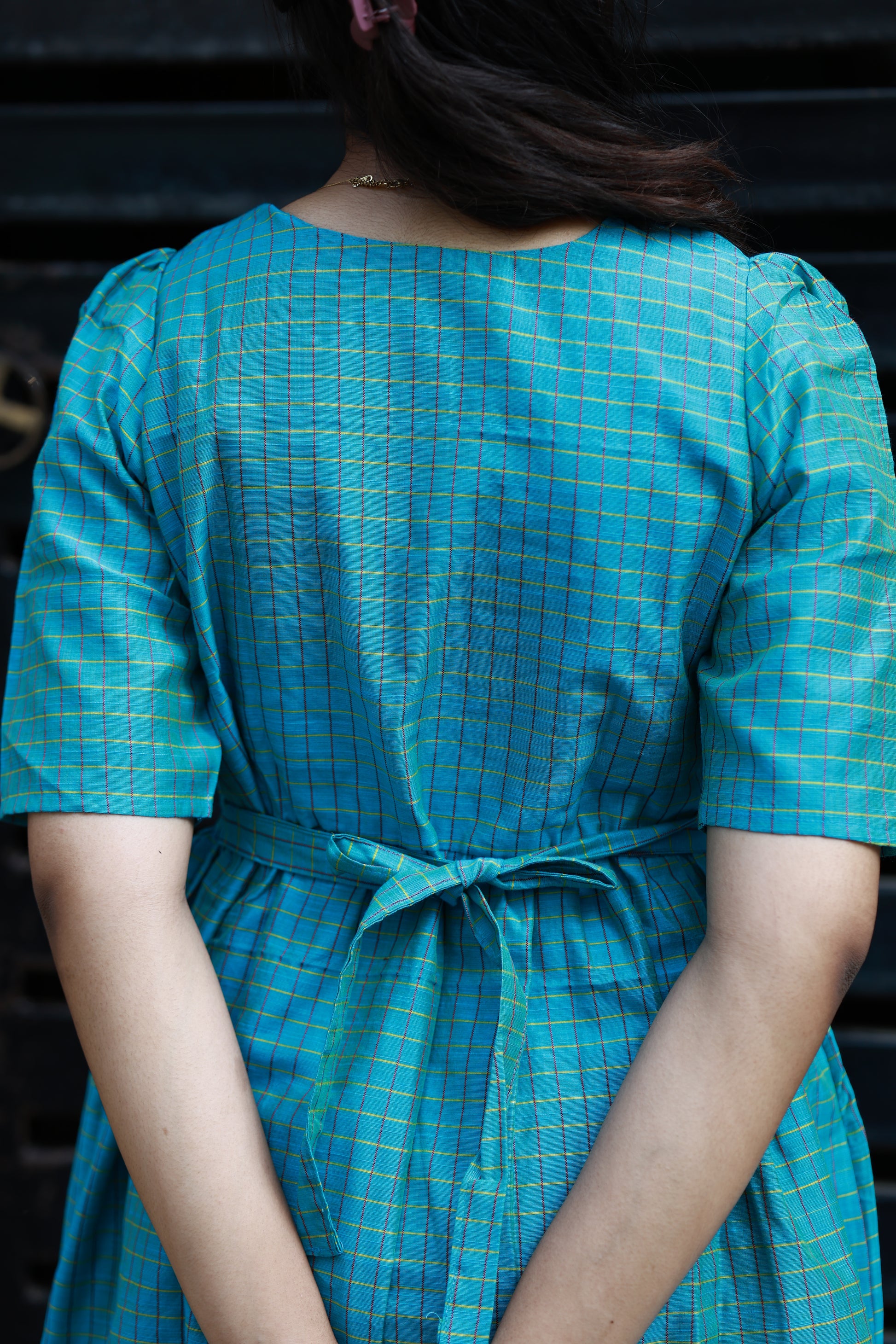 Neemai back view teal butter silk checkered maternity dress with tie-up detail, bump friendly ethnic wear, comfortable office wear for pregnancy moms
