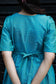 Neemai back view teal butter silk checkered maternity dress with tie-up detail, bump friendly ethnic wear, comfortable office wear for pregnancy moms