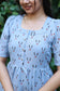 Neemai blue printed muslin feeding dress with front button nursing access, lightweight cotton fabric and elegant square neckline design.